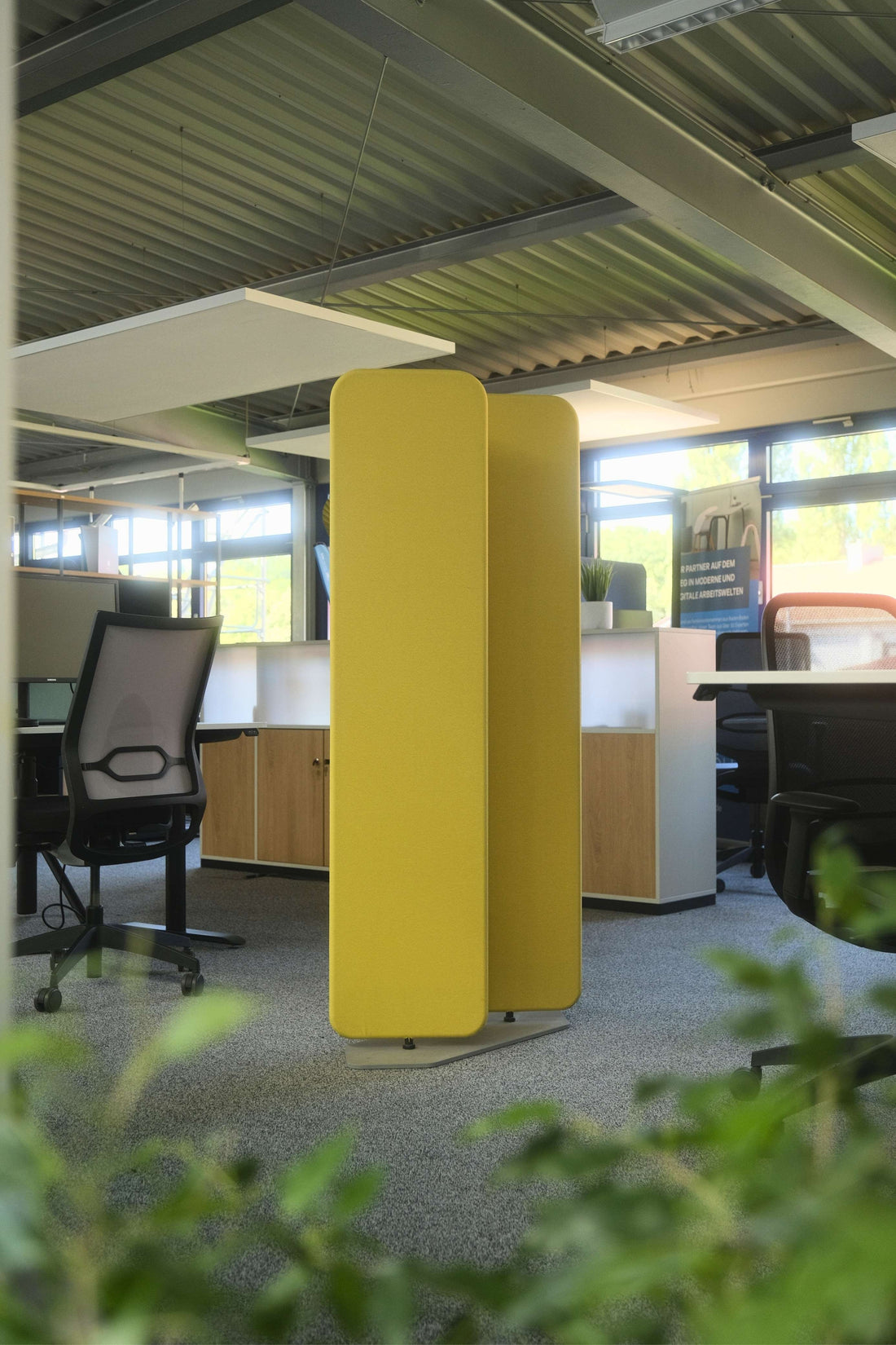 Gelbe Akustik-Stellwand zwischen Arbeitsplätzen in einem Büro