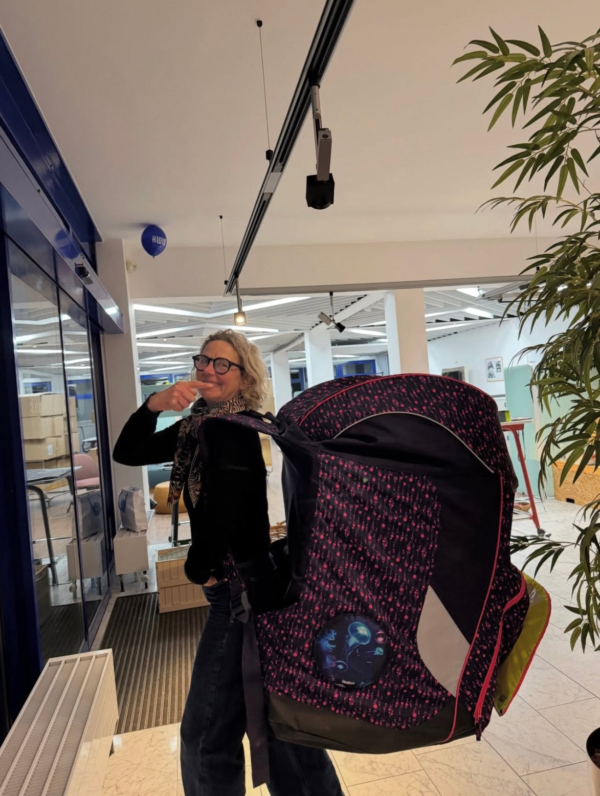 Mitarbeiterin hält einen Schulranzen hoch im Höll-Showroom