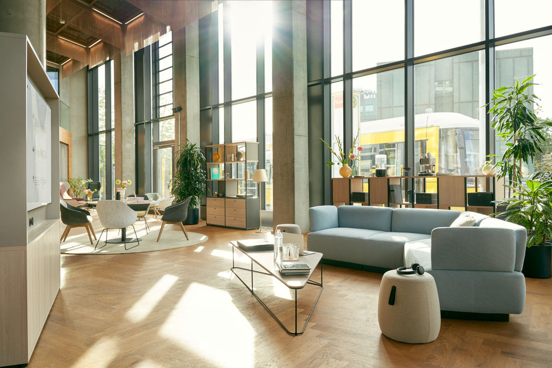 Großzügiger Empfangsbereich mit Sofa, Couchtisch und hoher Fensterfront