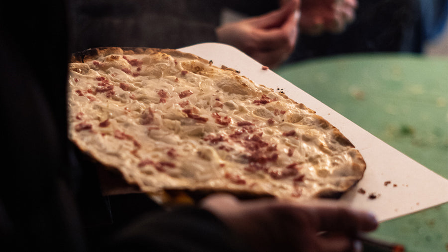 Frischer Flammkuchen auf einem Holzbrett